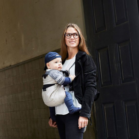 A woman using Enomo baby carrier