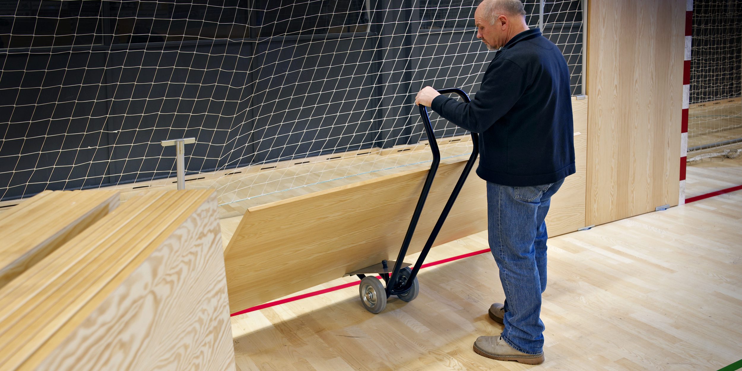 a man using Virklund Sport's warehouse dolly cart (bandevogn)